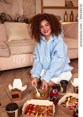 Young woman eating sushi at home. Home food delivery concept. Japan food. Top view. Space for text 96689036