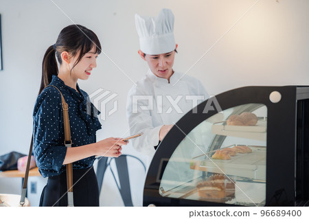 Young woman choosing sweets at the shop 96689400