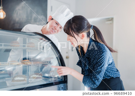 年輕女子在店裡挑選糖果 年輕女子在店裡挑選糖果 96689410