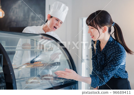 年輕女子在店裡挑選糖果 年輕女子在店裡挑選糖果 96689411