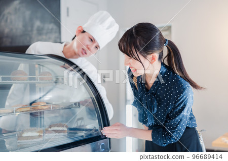年輕女子在店裡挑選糖果 年輕女子在店裡挑選糖果 96689414