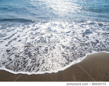 The beach of the blue sea that reflects the sunlight and sparkles. 96689735