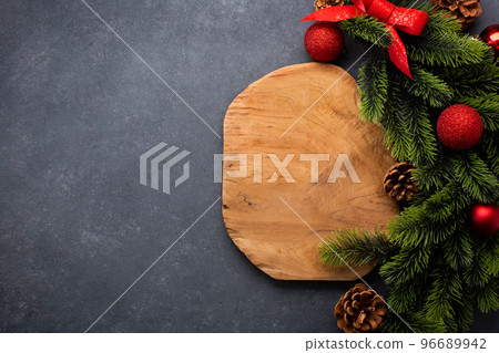 Christmas table setting consisting of a cutting board and cutlery tied with a bow. Top view with copy space Christmas table setting consisting of a cutting board and cutlery tied with a bow. Top view with copy space 96689942