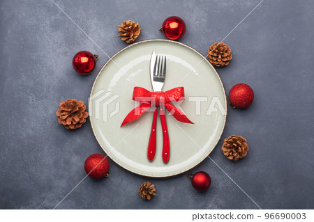 Christmas table setting consisting of a plate and cutlery tied with a bow. Flat lay Christmas table setting consisting of a plate and cutlery tied with a bow. Flat lay 96690003