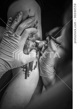 Skin master doing tattoo picture in tattoo studio 96690559