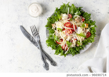 Traditional caesar salad with chicken on a plate on white table with napkin fork and knife. Traditional caesar salad with chicken on a plate on white table with napkin fork and knife. 96690714