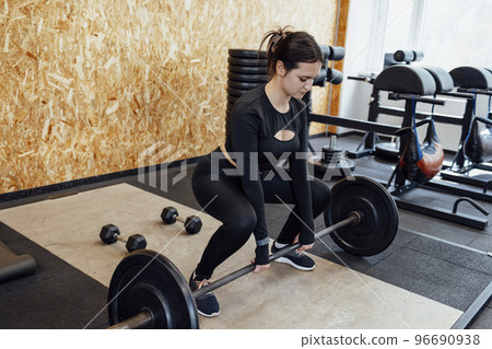 Strong brunette female doing crossfit workout Strong brunette female doing crossfit workout 96690938