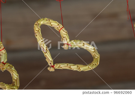 Straw heart with red ribbons on a gray background. The concept for Valentine's Day 96692060