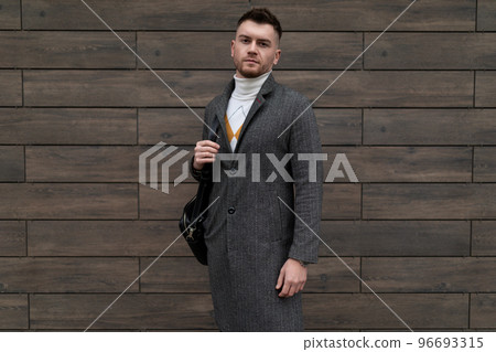 portrait of a successful young businessman in business clothes with a mobile phone in his hands in portrait of a successful young businessman in business clothes with a mobile phone in his hands in 96693315