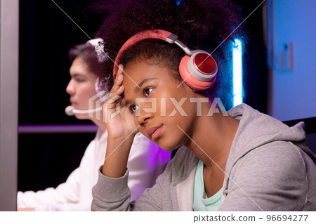 Young African American woman wearing headset play video game and live streaming online. 96694277