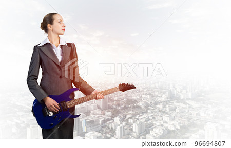Young businesswoman with electric guitar Young businesswoman with electric guitar 96694807