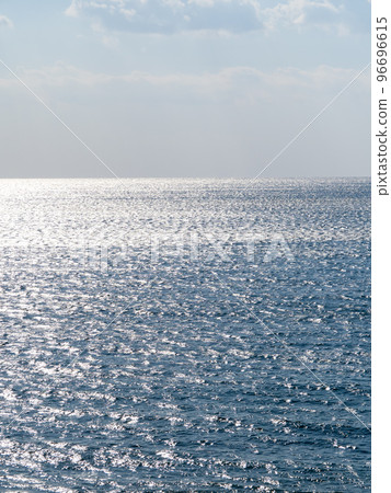 The blue sea that reflects the sunlight and glitters. 96696615