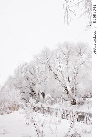 Snow-covered landscape of open spaces near the river. Snowy weather 96698041