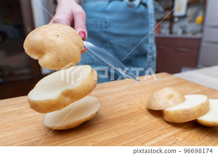 woman slicing potatoes 96698174