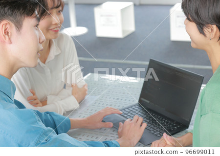 三個商務人士圍著 PC_1 開會 96699011