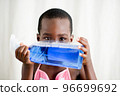 little boy hiding his face with a bottle of liquid soap 96699692