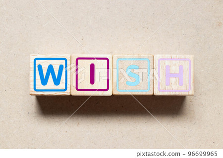 Color letter block in word wish on wood background Color letter block in word wish on wood background 96699965