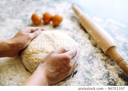 Making dough by female hands on wooden table background. Cooking concept. Lovely female hands. 96701397