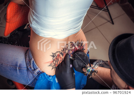 Tattooer doing tattoo in tatoo salon 96701924