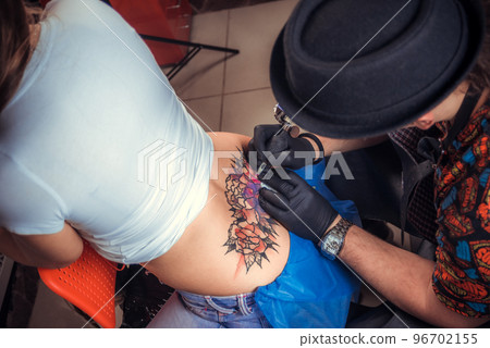 Master makes tattoo pictures in tattoo studio 96702155