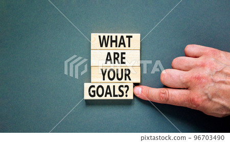 What are your goals symbol. Concept words What are your goals on wooden blocks. Beautiful grey table grey background. Businessman hand. Business psychological what are your goals concept. Copy space What are your goals symbol. Concept words What are your goals on wooden blocks. Beautiful grey table grey background. Businessman hand. Business psychological what are your goals concept. Copy space 96703490