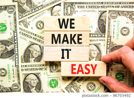 We make it easy symbol. Concept words We make it easy on wooden cubes. Beautiful background from dollar bills. Businessman hand. Business motivational we make it easy concept. Copy space. We make it easy symbol. Concept words We make it easy on wooden cubes. Beautiful background from dollar bills. Businessman hand. Business motivational we make it easy concept. Copy space. 96703492