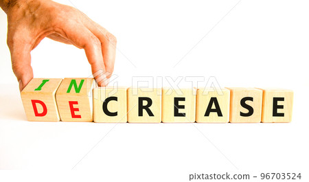 Increase or decrease symbol. Concept words Increase and Decrease on wooden cubes. Businessman hand. Beautiful white table white background. Business increase or decrease concept. Copy space. 96703524