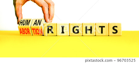 Abortion rights symbol. Concept words Abortion rights are human rights on wooden cubes. Businessman hand. Beautiful yellow table white background. Business medical abortion rights concept. Copy space. Abortion rights symbol. Concept words Abortion rights are human rights on wooden cubes. Businessman hand. Beautiful yellow table white background. Business medical abortion rights concept. Copy space. 96703525