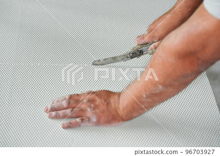 Man cutting polystyrene foam heat insulation with old retractable utility knife, closeup detail 96703927