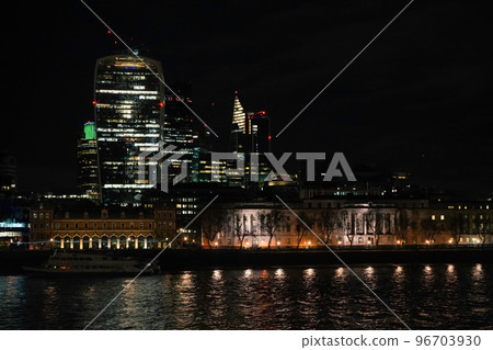 Night view of London skyscrapers at Bishopsgate, river Thames in foreground 96703930