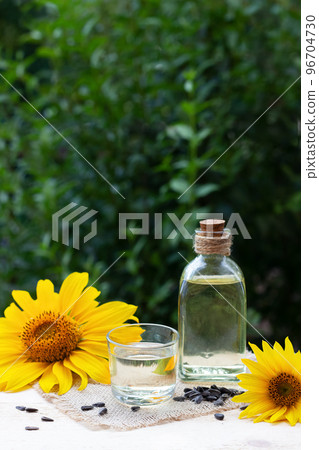 Close-up of sunflower oil in a bottle glass with seeds and sunflower 96704730