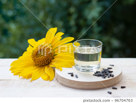 Close-up of sunflower oil in glass with seeds and sunflower 96704763