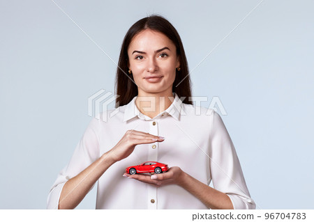 beautiful woman in white shirt holding little red car 96704783