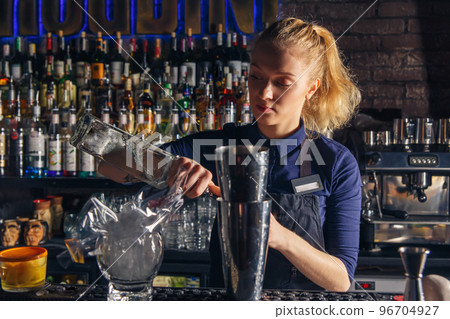 Woman bartender making an alcohol cocktail Woman bartender making an alcohol cocktail 96704927
