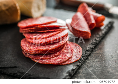Sliced mexican salami with beans on cutting board. Sliced mexican salami with beans on cutting board. 96704972
