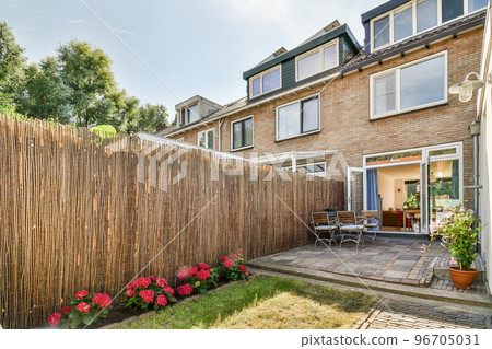 Neat powerful patio with sitting area and small garden near wooden fence Neat powerful patio with sitting area and small garden near wooden fence 96705031