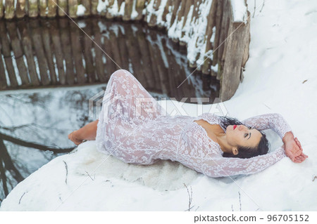 Attractive woman lying near the font in a white dress 96705152
