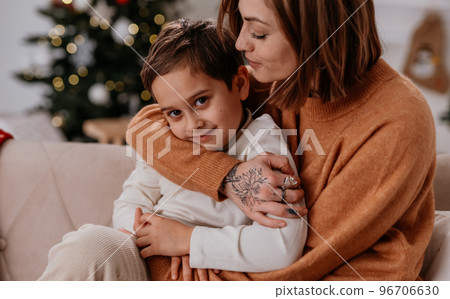 Happy family of loving mother and son hugs and smiling at cozy winter evening at home 96706630
