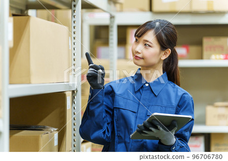 A female worker who manages inventory in a warehouse 96706780