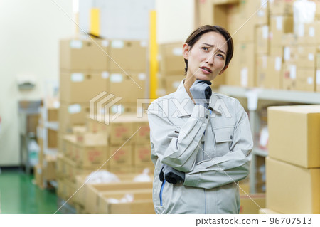 A female worker who is worried in the warehouse A female worker who is worried in the warehouse 96707513