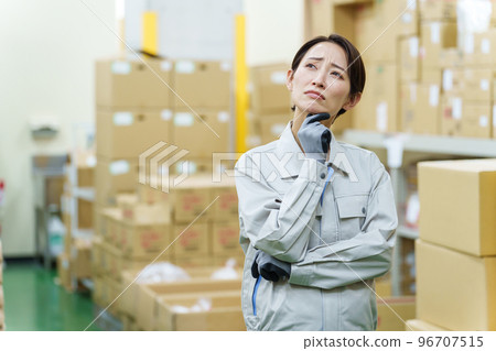 A female worker who is worried in the warehouse 96707515