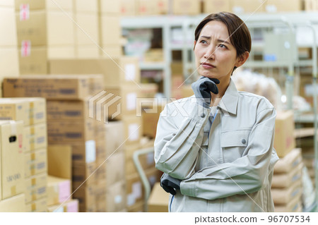 A female worker who is worried in the warehouse 96707534