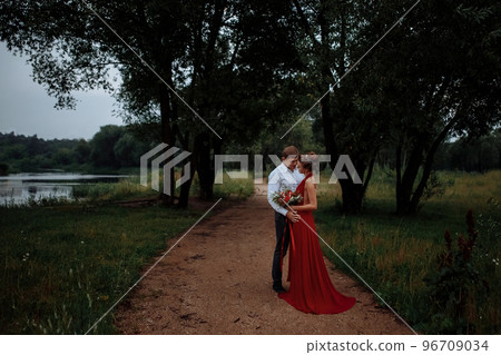 An elegant man in a shirt hugs a slender girl. An elegant man in a shirt hugs a slender girl. 96709034