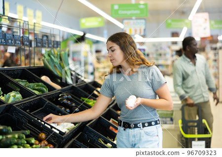 Portrait of woman buying fresh champignon mushrooms in grocery shop 96709323