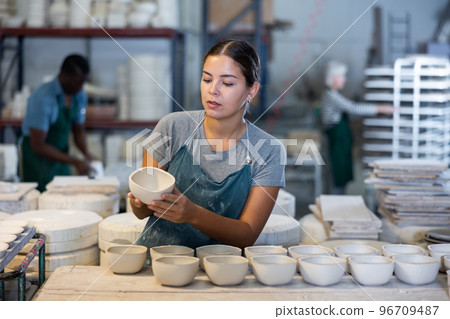 Young woman potter with new crafted ceramic bowls 96709487