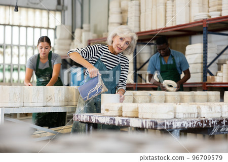 Senior woman ceramist working in pottery workshop Senior woman ceramist working in pottery workshop 96709579