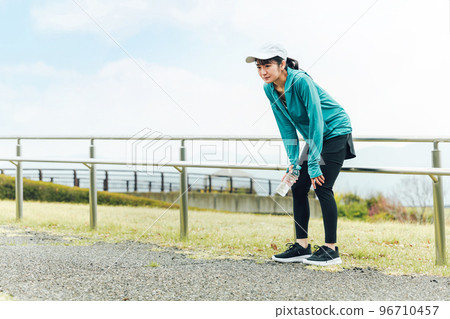 Runner Asian woman doing aerobic exercise while feeling tired due to cold 96710457