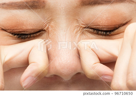 A woman rubbing her eyes and nose. A woman rubbing her eyes and nose. 96710650