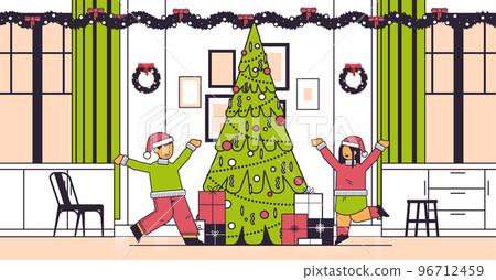 little children in santa hats happy to found gifts near fir tree new year christmas holidays celebration concept 96712459