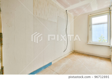 Empty room with windows and radiator in daylight 96712891